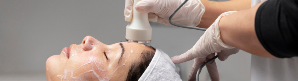 Profissional realizando procedimento de radiofrequência facial em cliente do sexo feminino